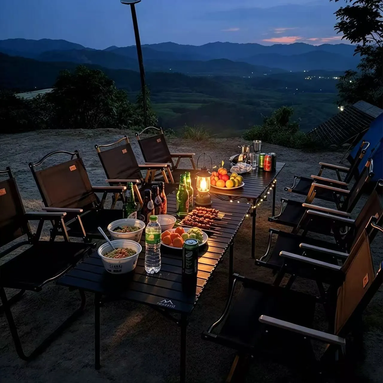 Evening camp dinner with lantern and mountain view